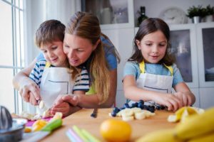 Mujer enseñando a sus hijos a cocinar